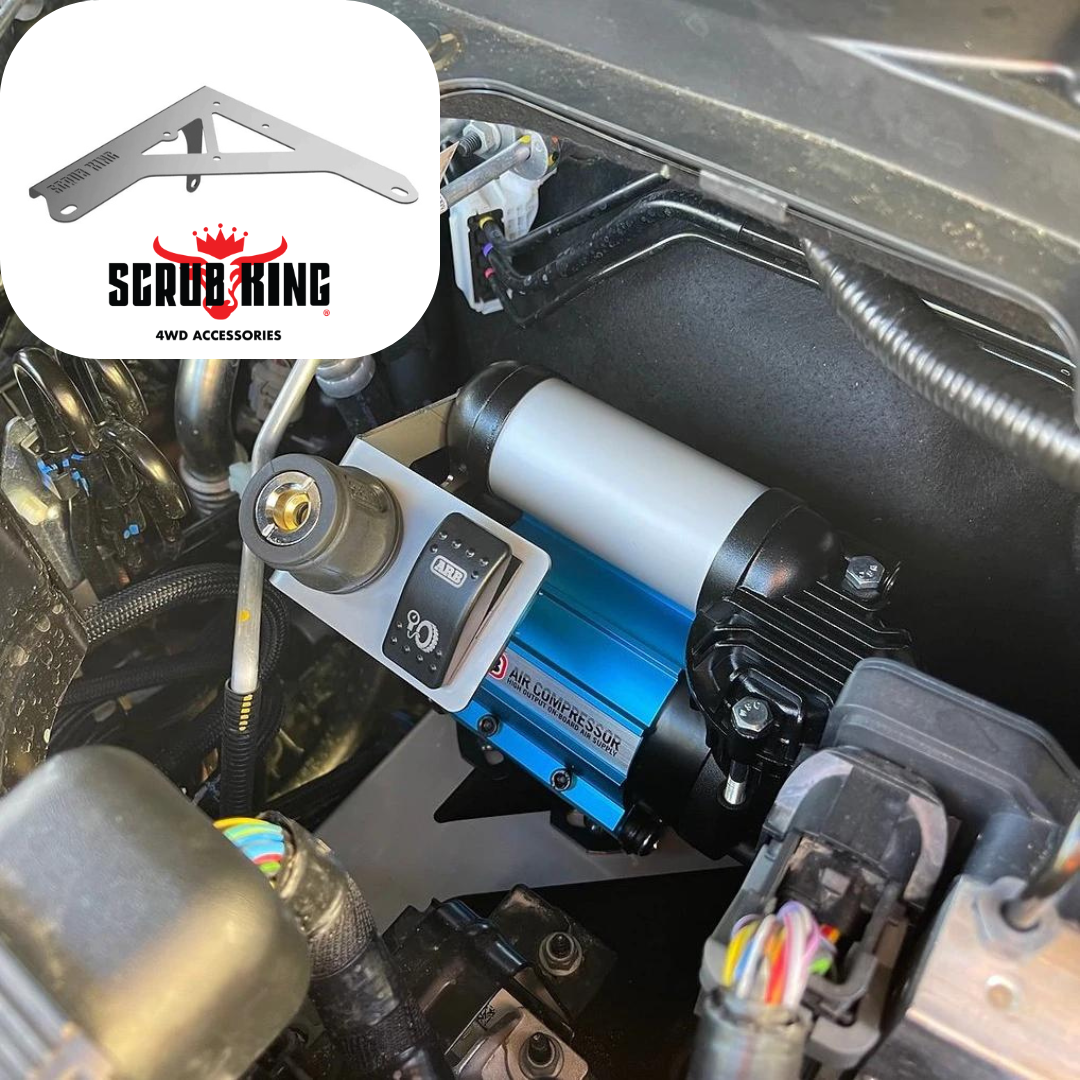 Stainless steel on-board air compressor mount installed in the engine bay of a vehicle.